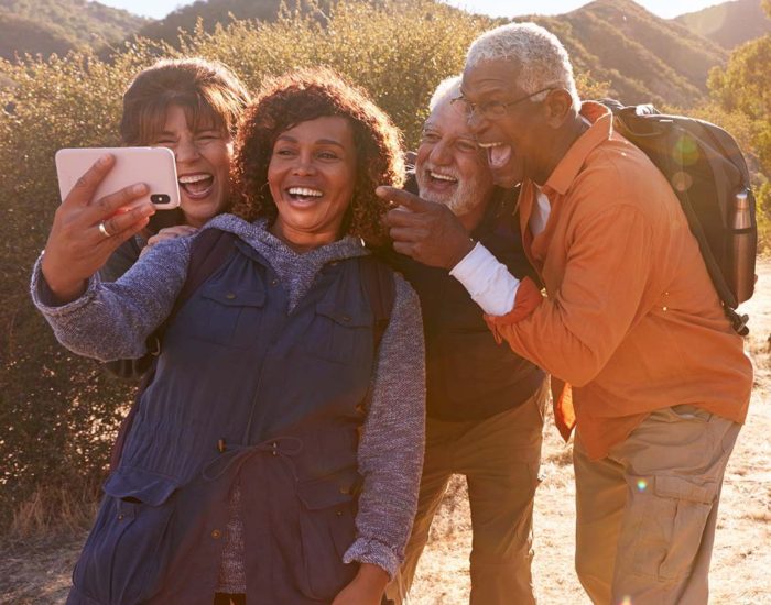 Group Of Senior Friends Posing For Selfie As They Hike Along Trail In Countryside Together